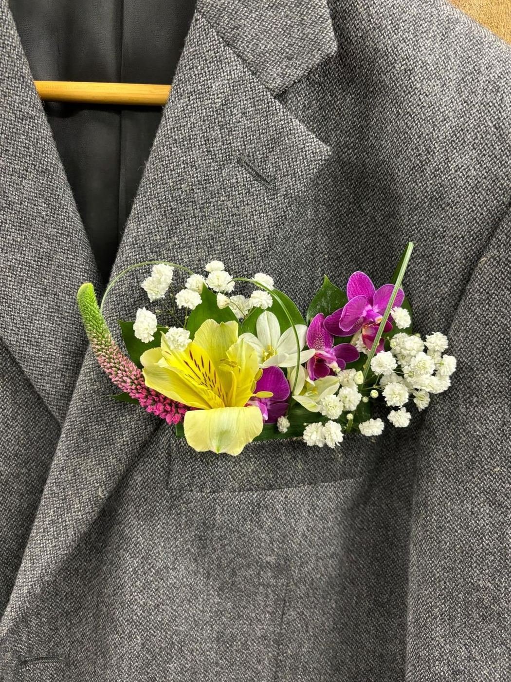 Pocket boutonnière of alstroemeria, orchids and baby's breath